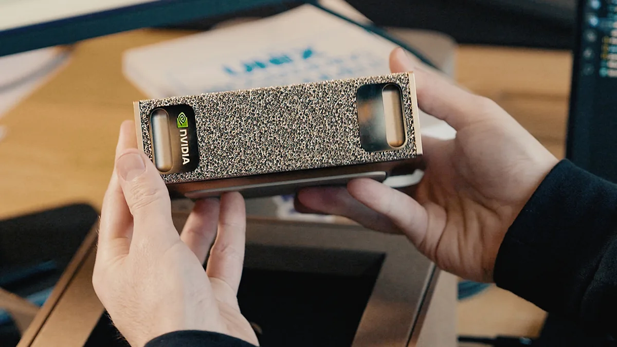 DGX Spark held in two hands — the whole platform at desk-side scale